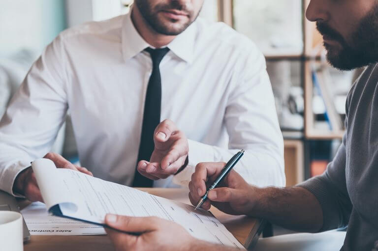 Two men signing a contract