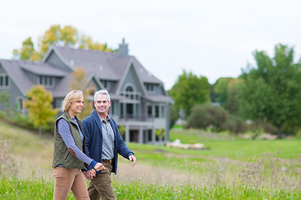 A happy couple taking a walk on their luxury Lakeview Orono lot